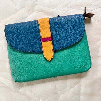 seafoam saddle bag with blue flap and yellow tab.