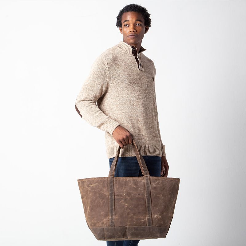 a person holdign the kahki waxed tote