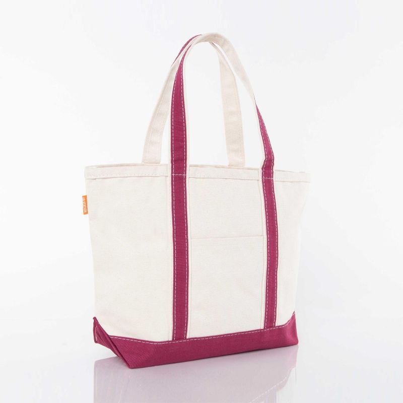angled view of off white tote with maroon trim and handles