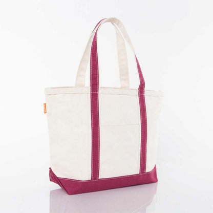 angled view of off white tote with maroon trim and handles
