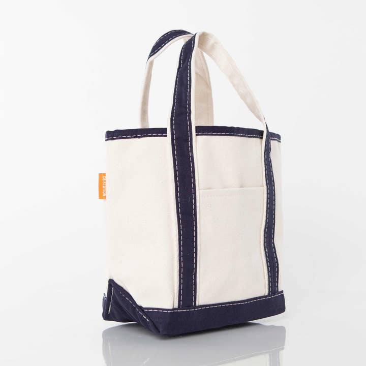angled view of off white tote with navy handles and trim