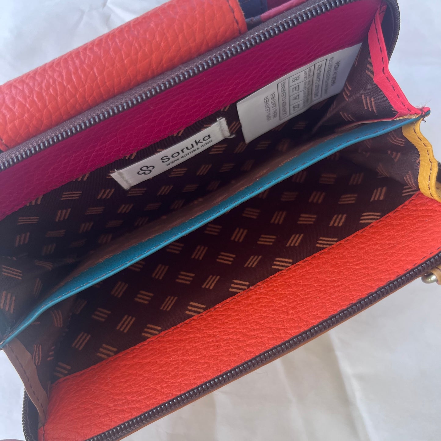 interior view of orange Beatrice Clutch zippered compartment