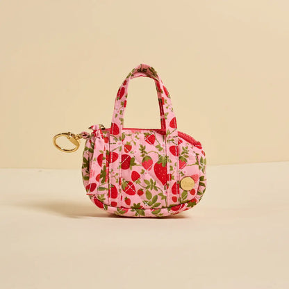 tiny duffle bag with strawberry pattern on a beige background