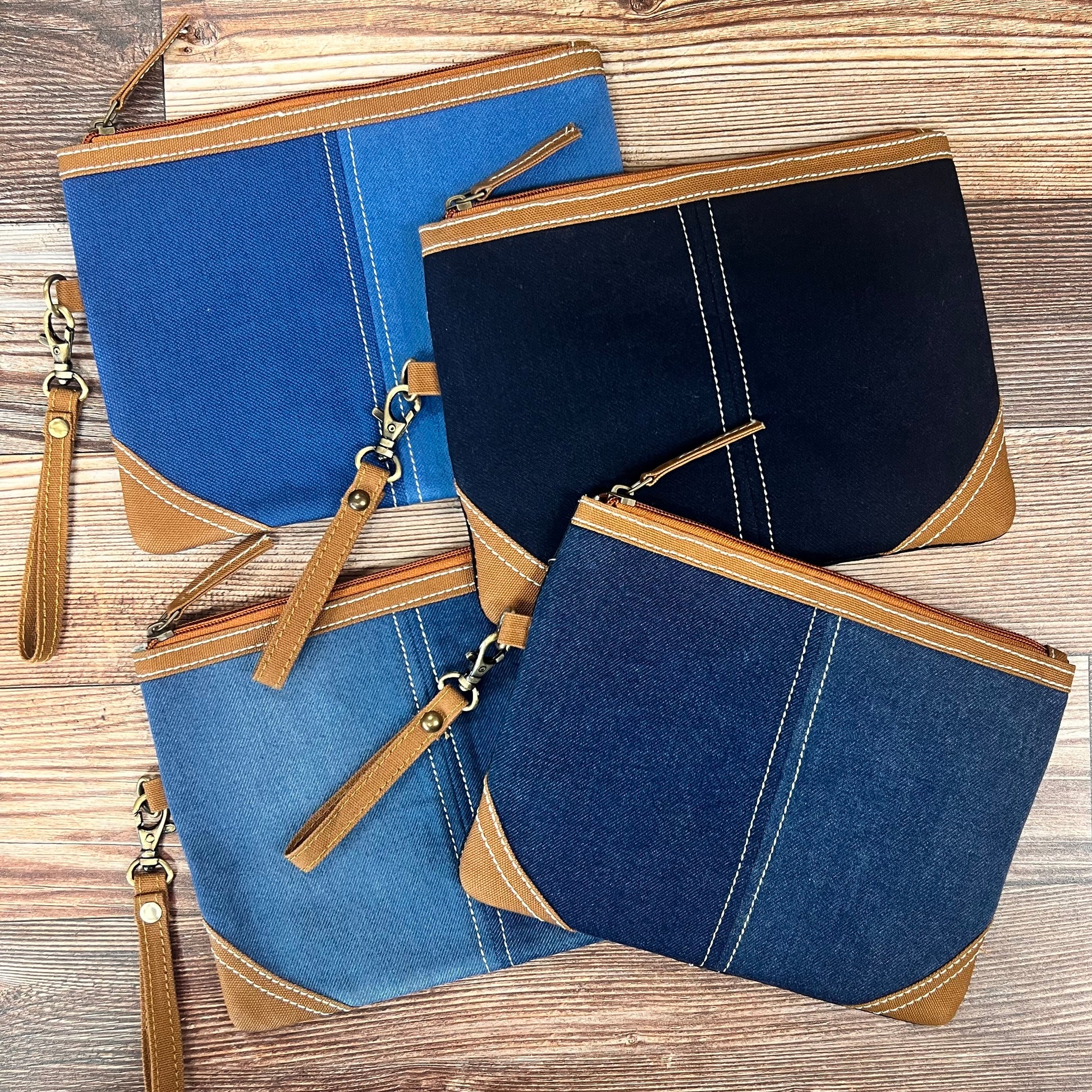 4 assorted denim wristlets arrange on a wood slat background.