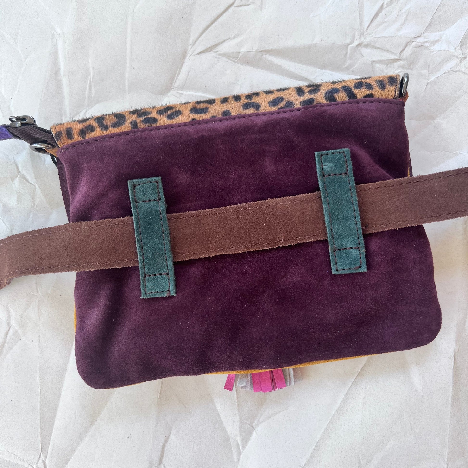 solid purple back of bag with loops holding belt.