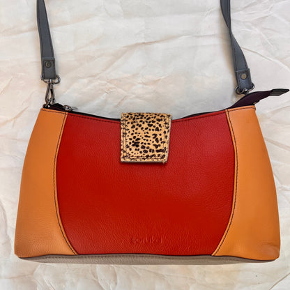 front on Amanda bag with color blocks of orange and an animal print tab over top zipper.