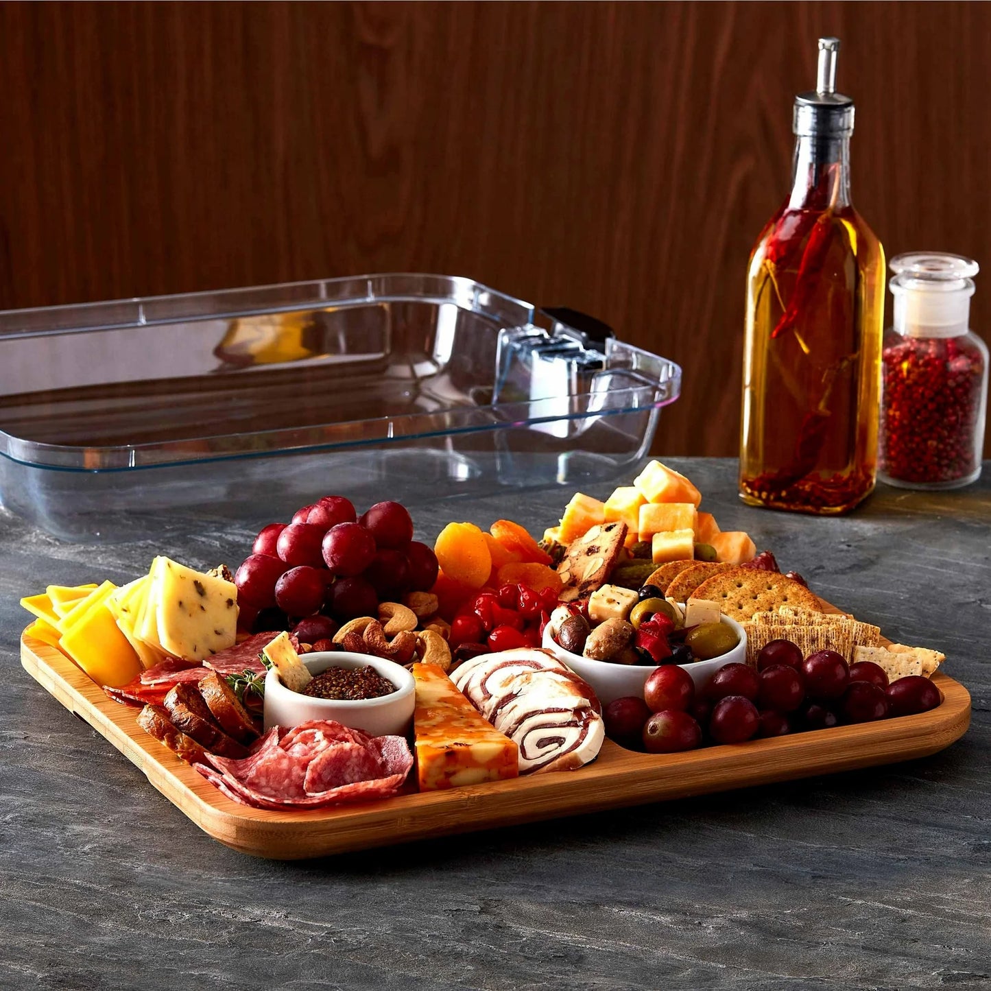 6 Section Build A Board filled with eat, cheeses and fruit set on a counter with the lid in the background