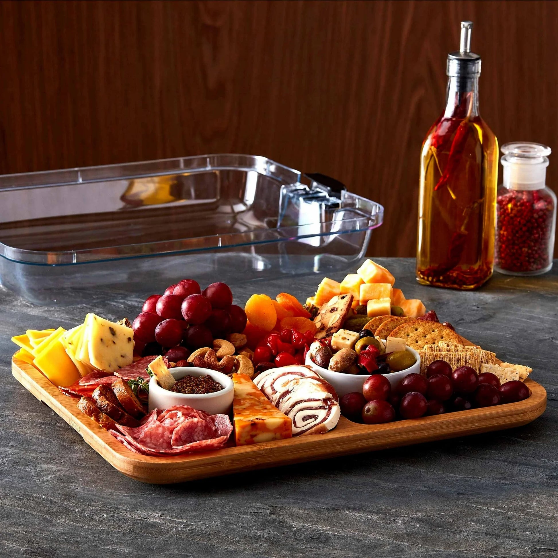 6 Section Build A Board filled with eat, cheeses and fruit set on a counter with the lid in the background