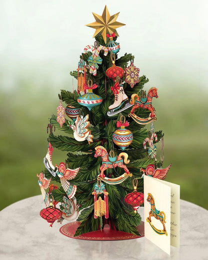 Pop up tree card set on a pedestal with its enclosure card that is printed with a rocking horse design