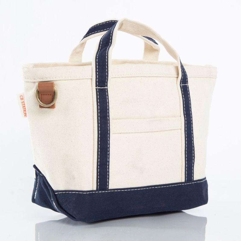 angled view of off-white tote with navy trim