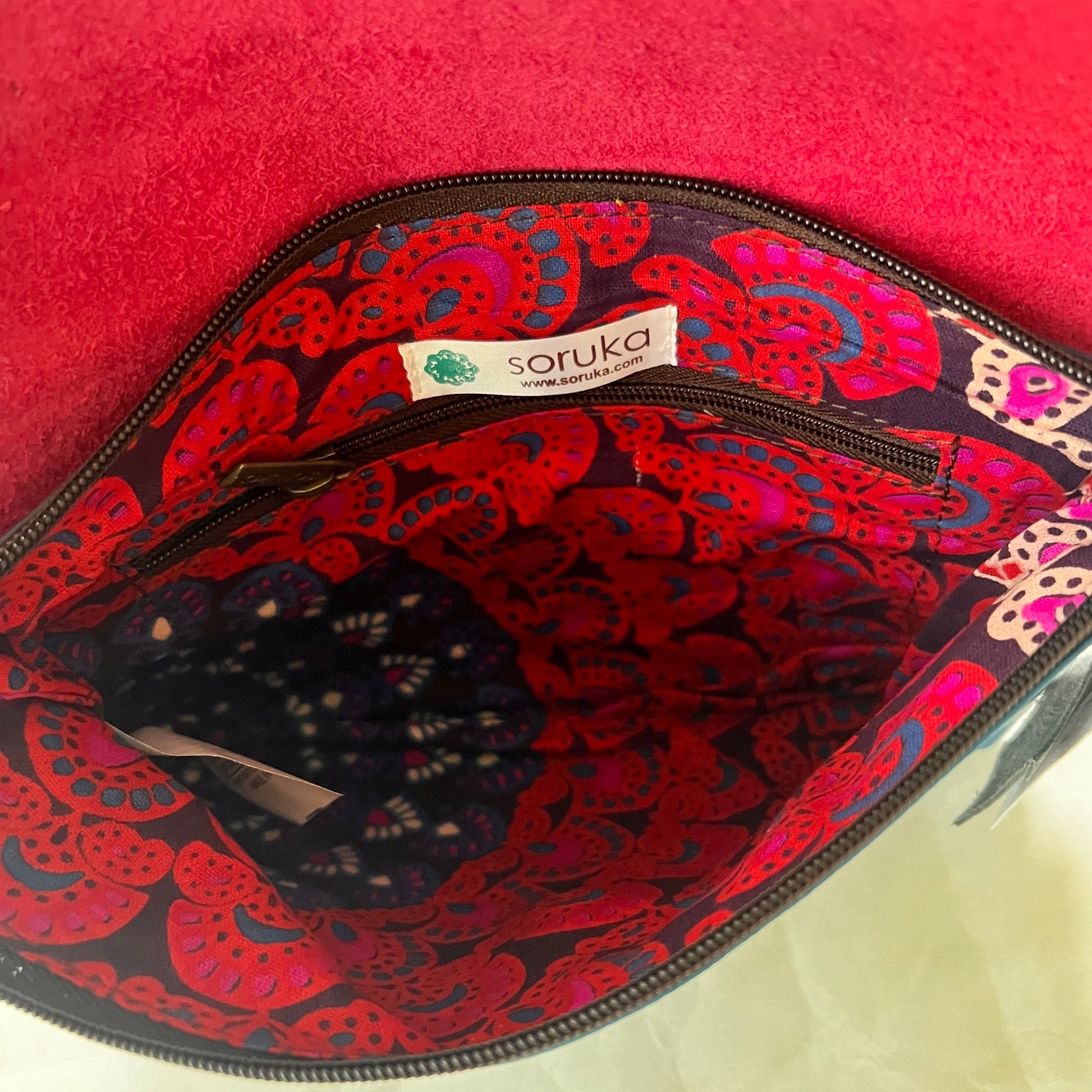 interior view of saddle bag showing inner zip pocket and patterned lining.