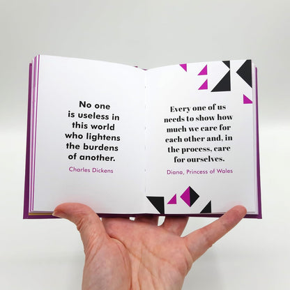 Open book with quotes by Charles Dickens and Princess of Wales held by a hand on a light gray background