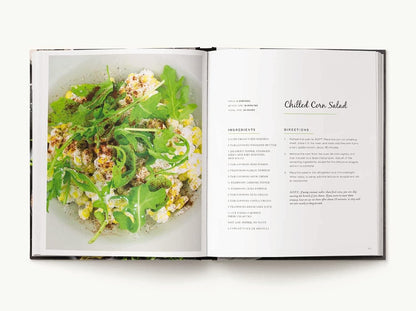 Open cookbook showing a page with a salad recipe and image of salad