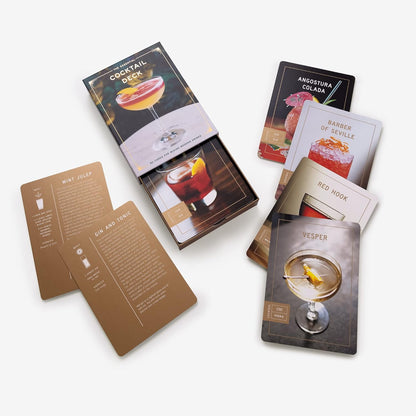 assorted cocktail cards including vesper, red hook, and barber of seville arranged on a white background.