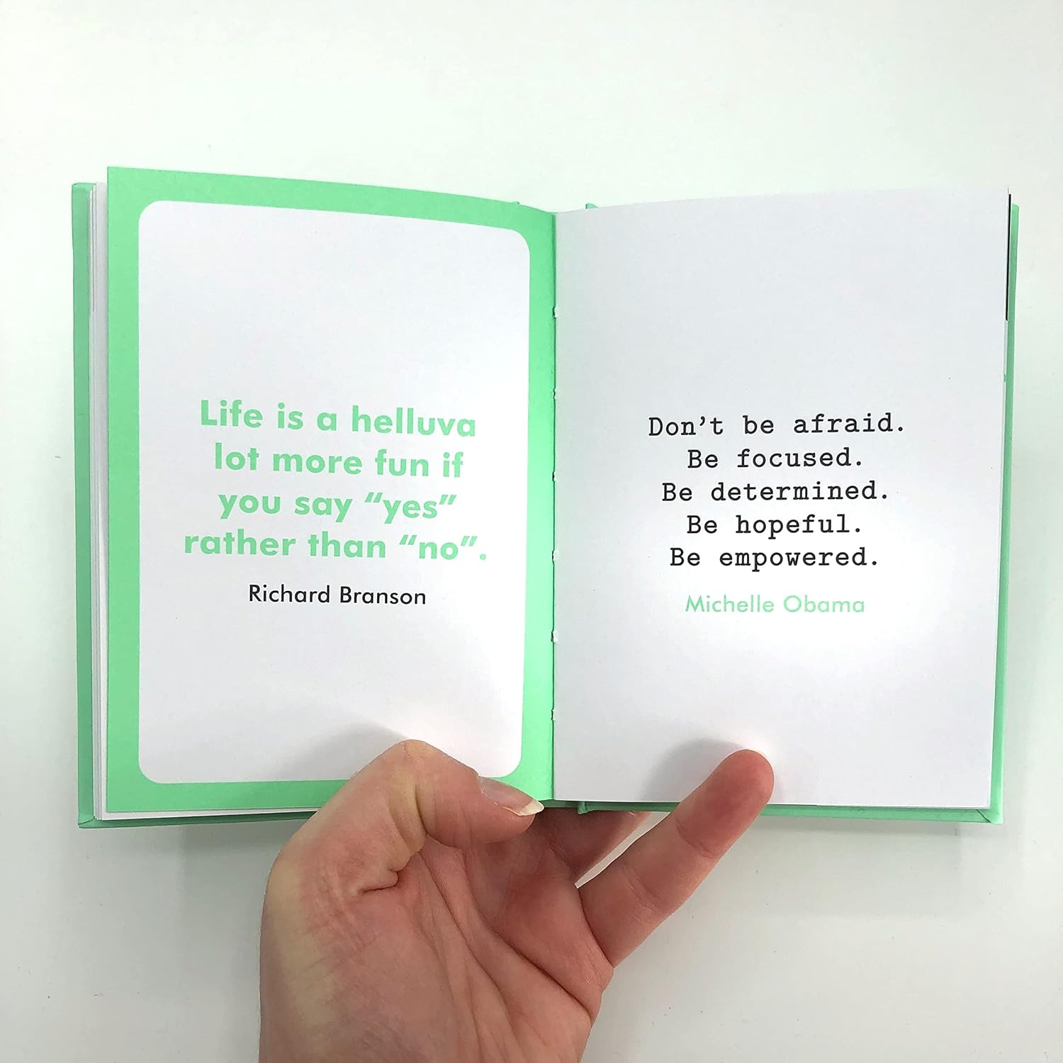 Open book with motivational quotes on a white background