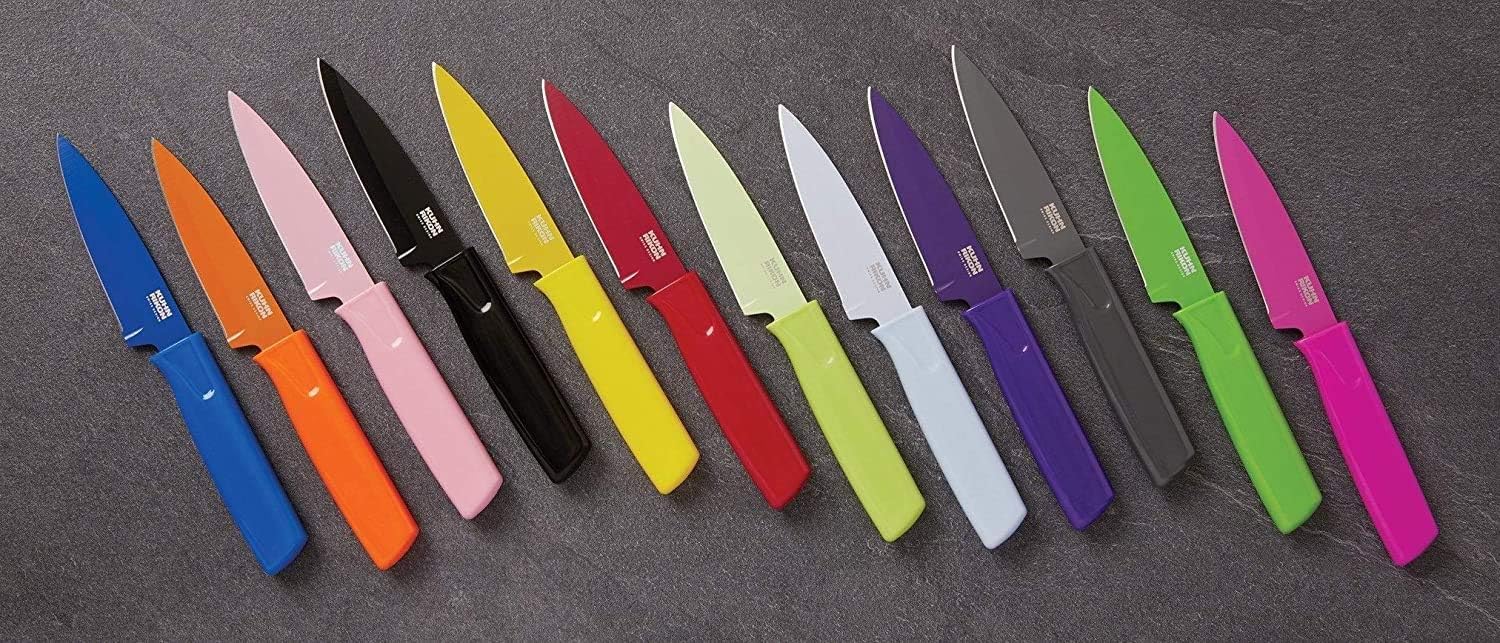 12 knives in a ssorted colors arranged in a row on a grey stone background.