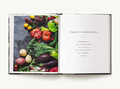 Open book with a table of contents and colorful vegetables on a dark surface