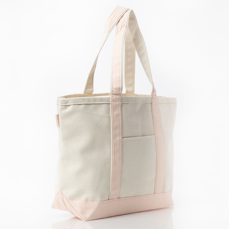 angled view of off white tote with pale pink trim and handles