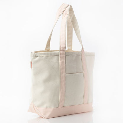 angled view of off white tote with pale pink trim and handles