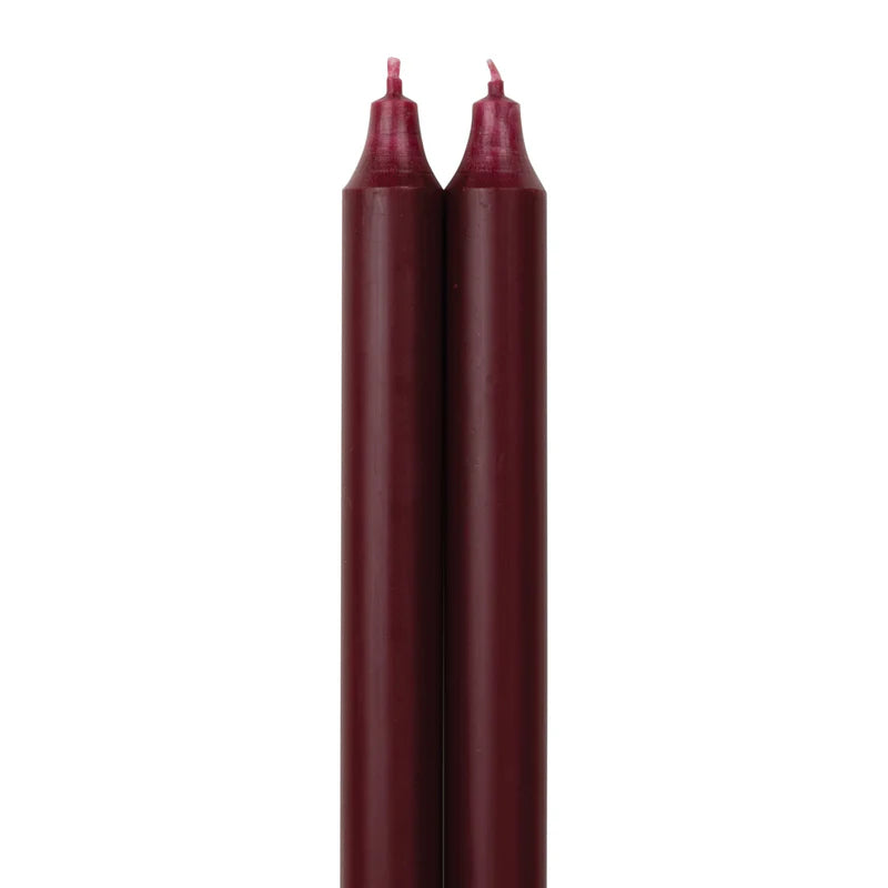 2 wine colored tapers on a white backbround.