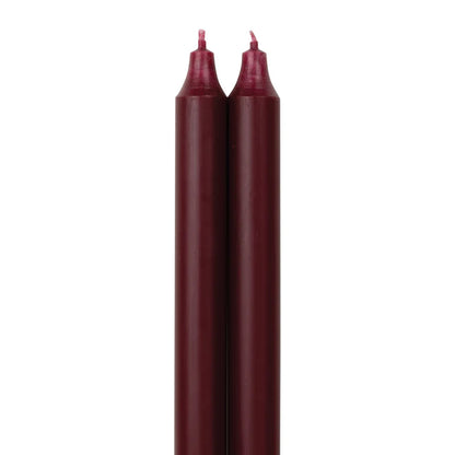 2 wine colored tapers on a white backbround.