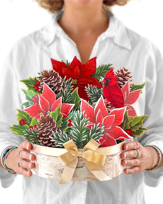 person wearing a white blouse holding Birch Poinsettia Pop-Up Bouquet