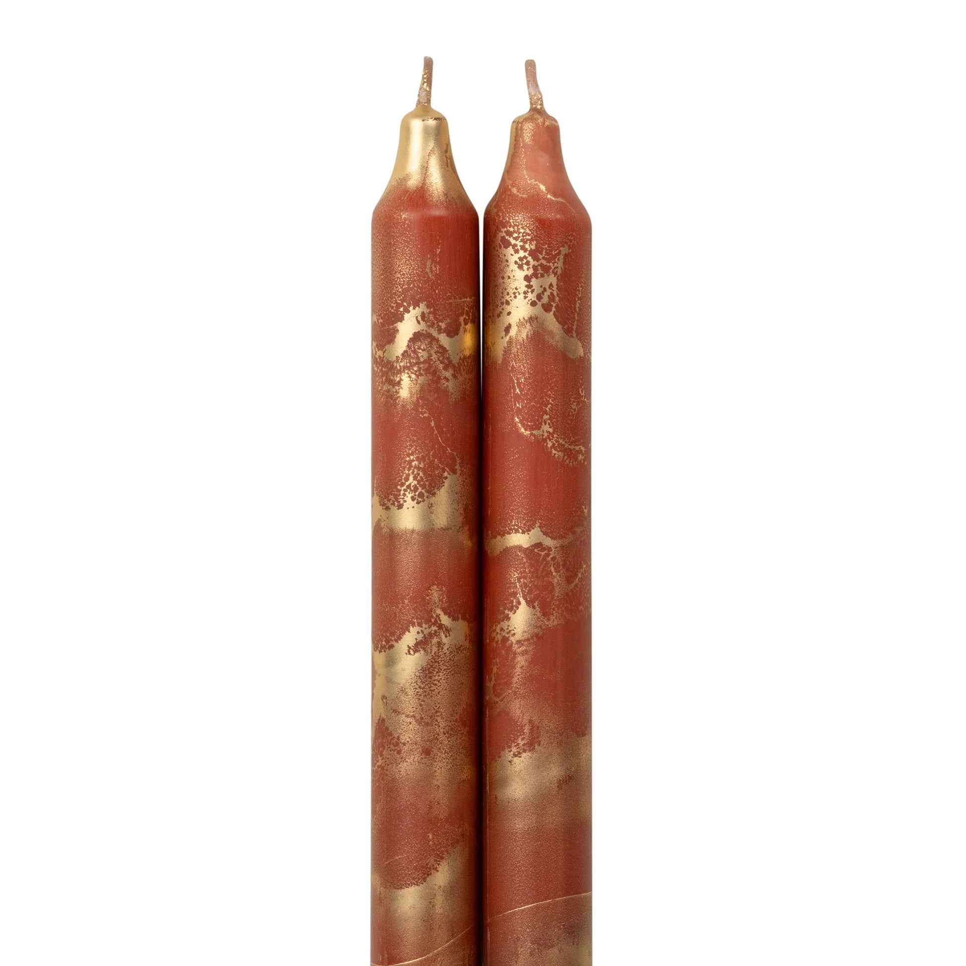 2 terracotta colored tapers with gold swirls on a white background.