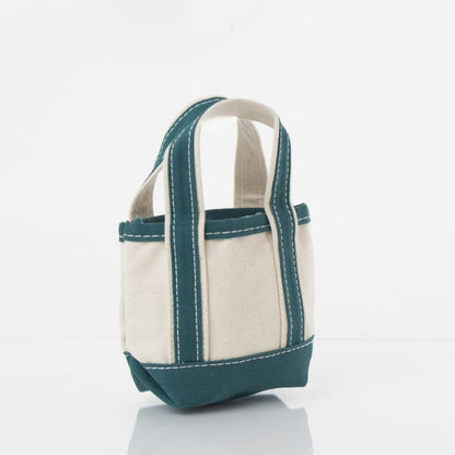 angled view of off white mini tote bag with teal green handles and trim
