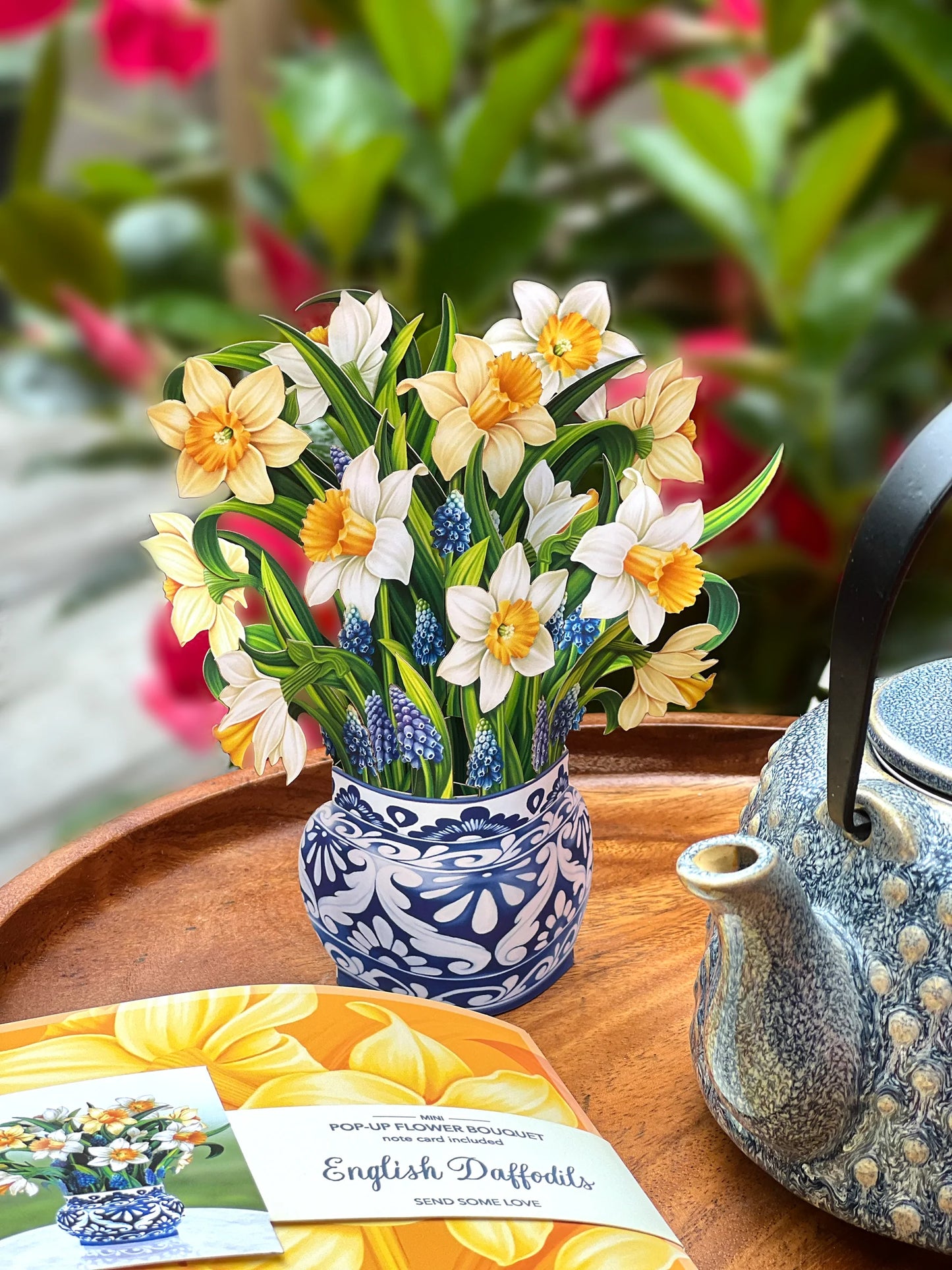 English Daffodils pop-up bouquet set on a table with a teapot next to it.
