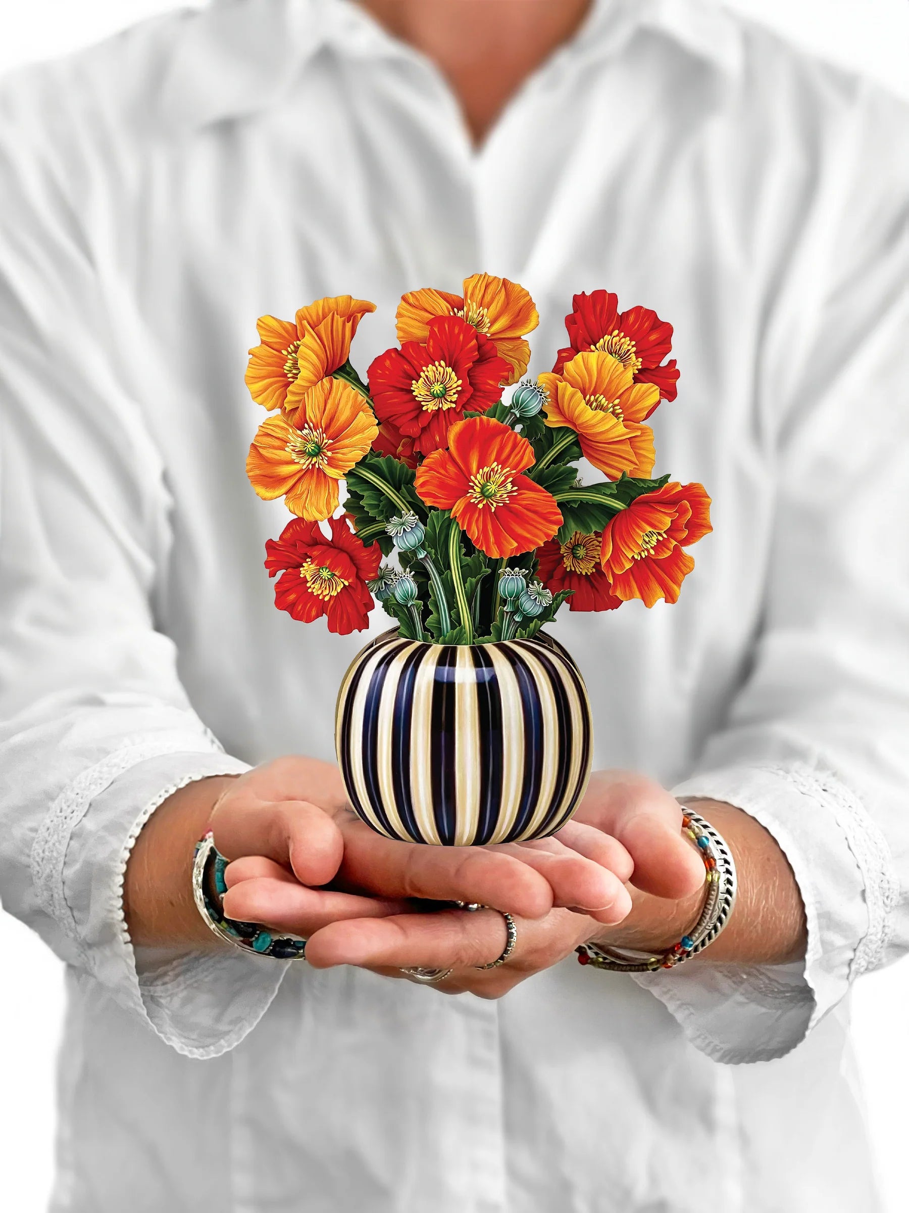 person holding French Poppies pop-up bouquet in front of them.