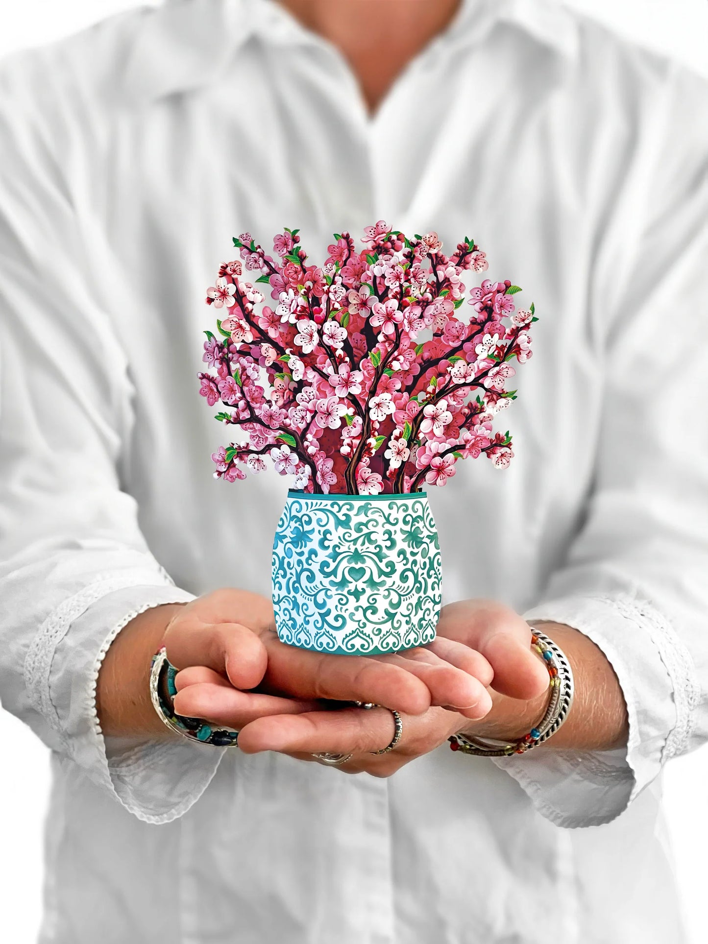 person holding Cherry Blossom pop up bouquet in front of them.
