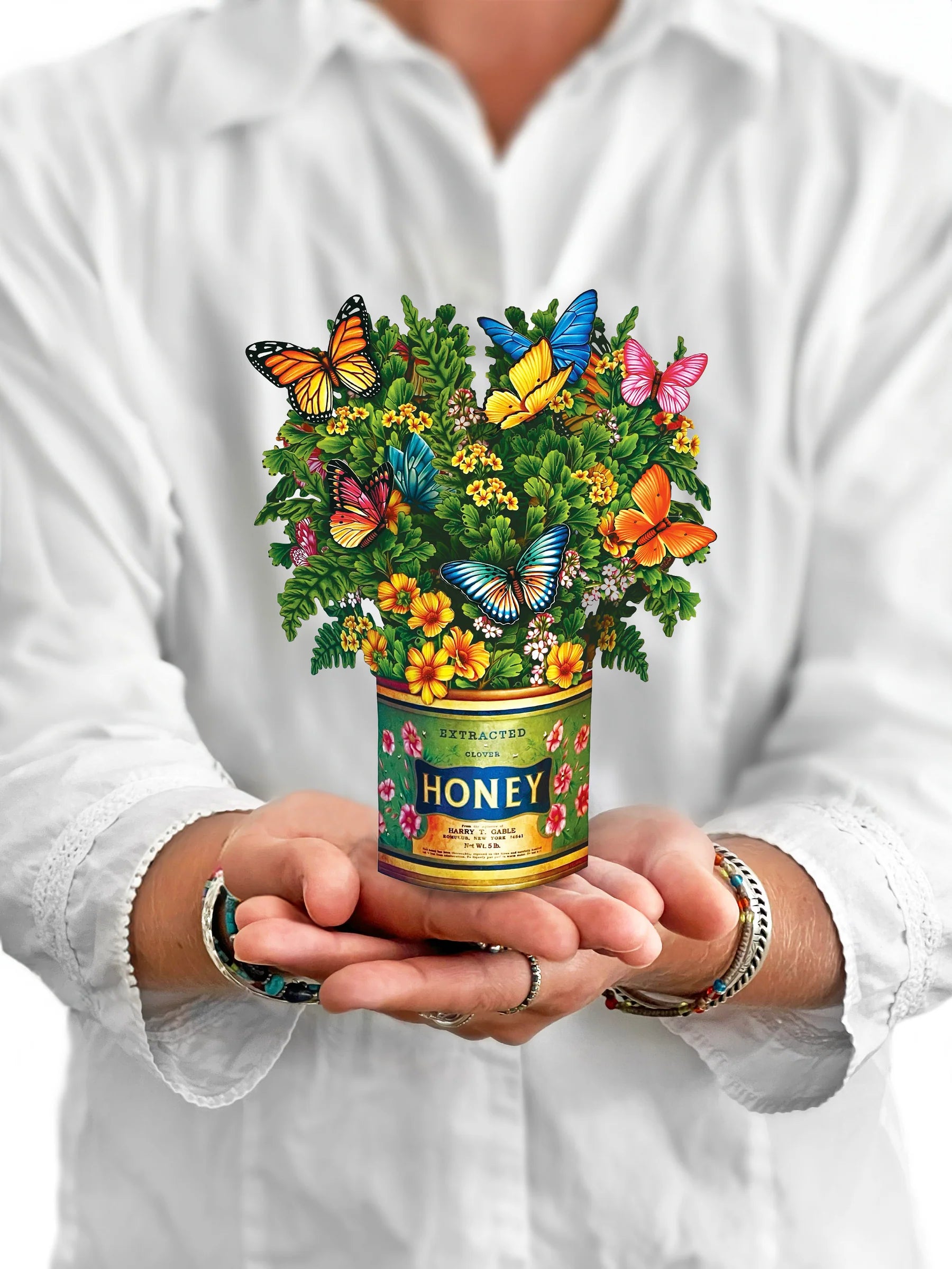 person holding Butterflies & Buttercups pop up bouquet in front of them.