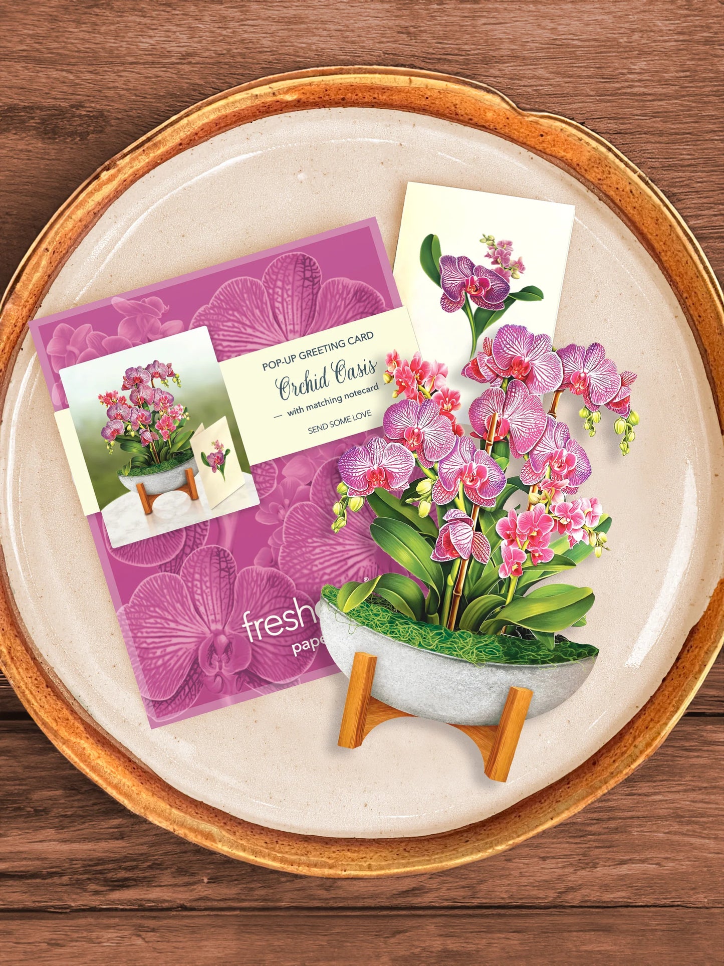 Orchid Oasis bouquet, enclosure card, and mailing envelope arranged on a tray.