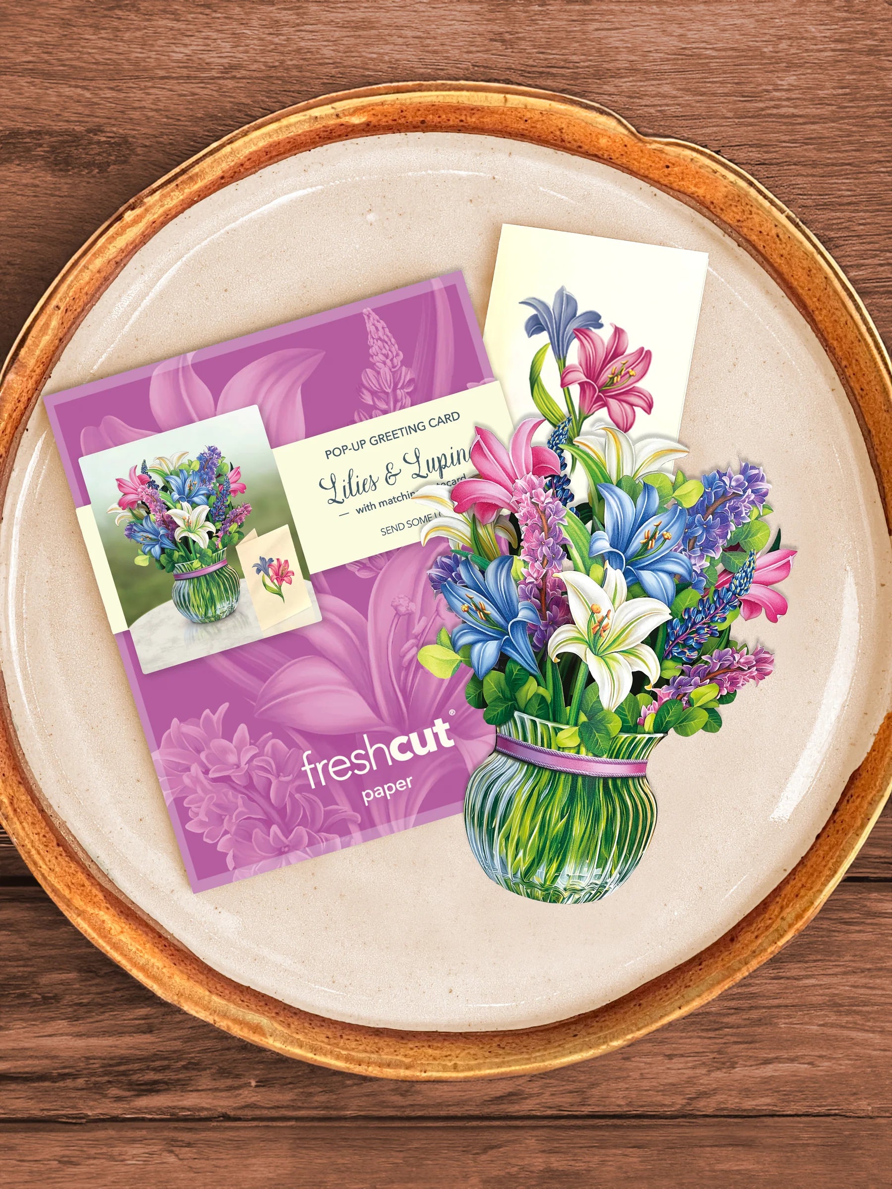 Lilies & Lupines bouquet, enclosure card, and mailing envelope arranged on a tray.