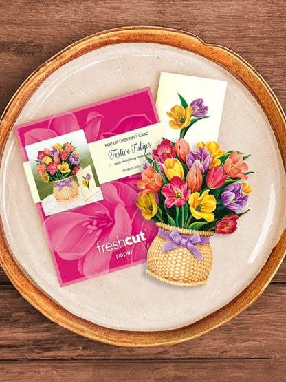 Festive Tulips bouquet, enclosure card, and mailing envelope arranged on a tray.