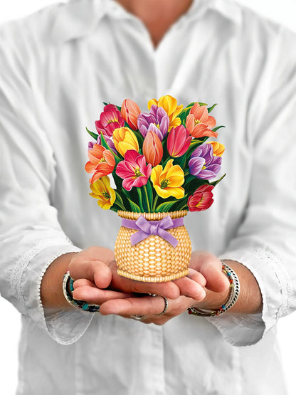 person holding Festive Tulips pop-up bouquet in front of them.