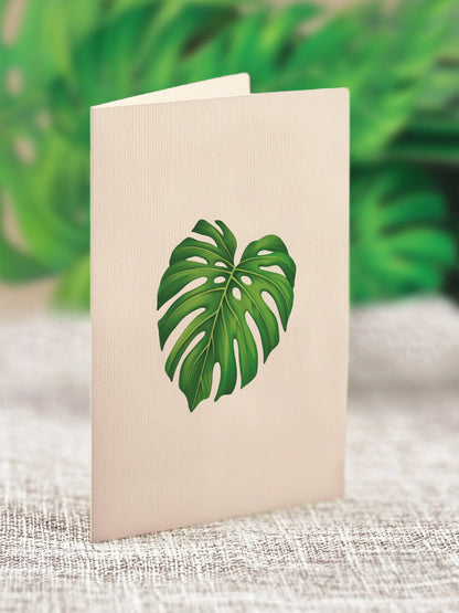 close-up of enclosure card with a Monstera leaf printed on it.