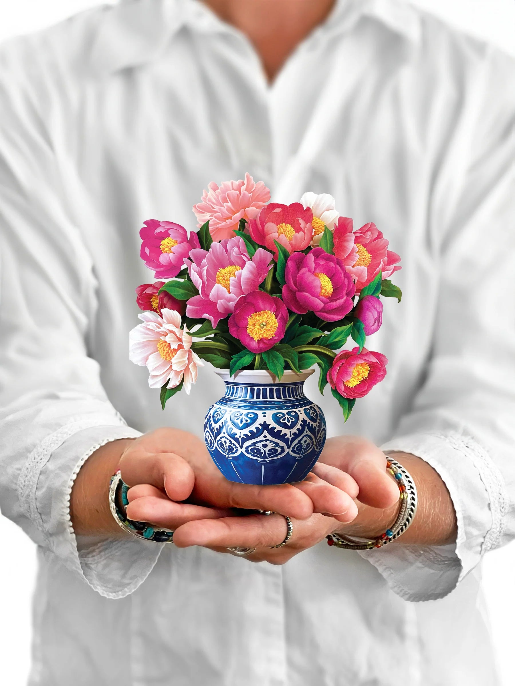 person holding Peony Paradise pop-up bouquet in front of them.