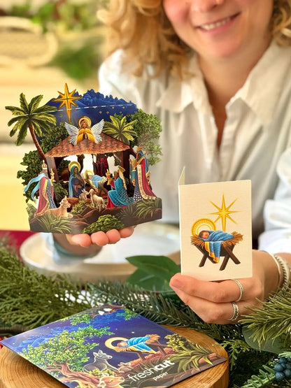 person holding Mini Nativity Pop-Up Card and reading enclosure card
