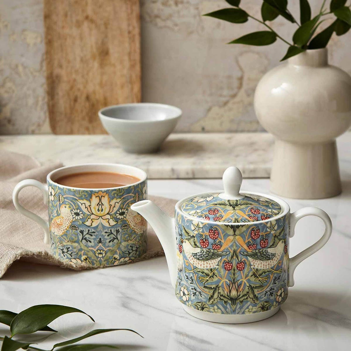 strawberry thief small teapot and a strawberry thief mug filled with tea on a decorated table