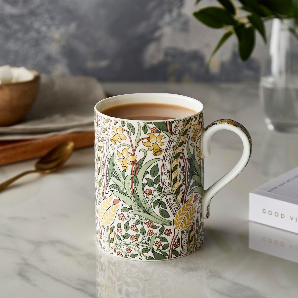 daffodil mug with coffee in it on a set table