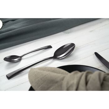 both spoons displayed on a light grey table with a plate and napkin in the foreground.