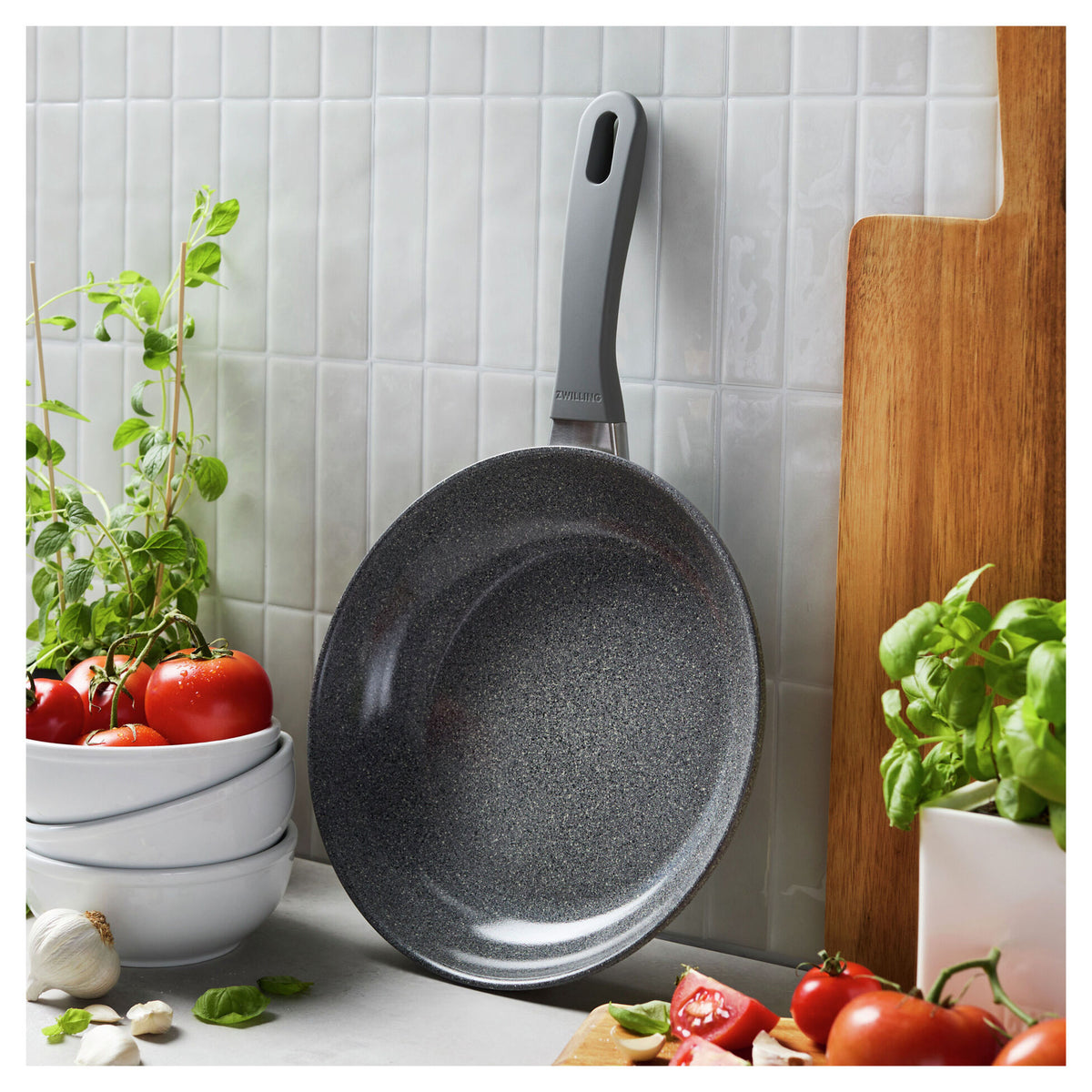 10" Parma Plus, Nonstick Ceramic Fry Pan leaning against a wall next to produce