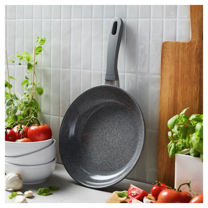 10" Parma Plus, Nonstick Ceramic Fry Pan leaning against a wall next to produce