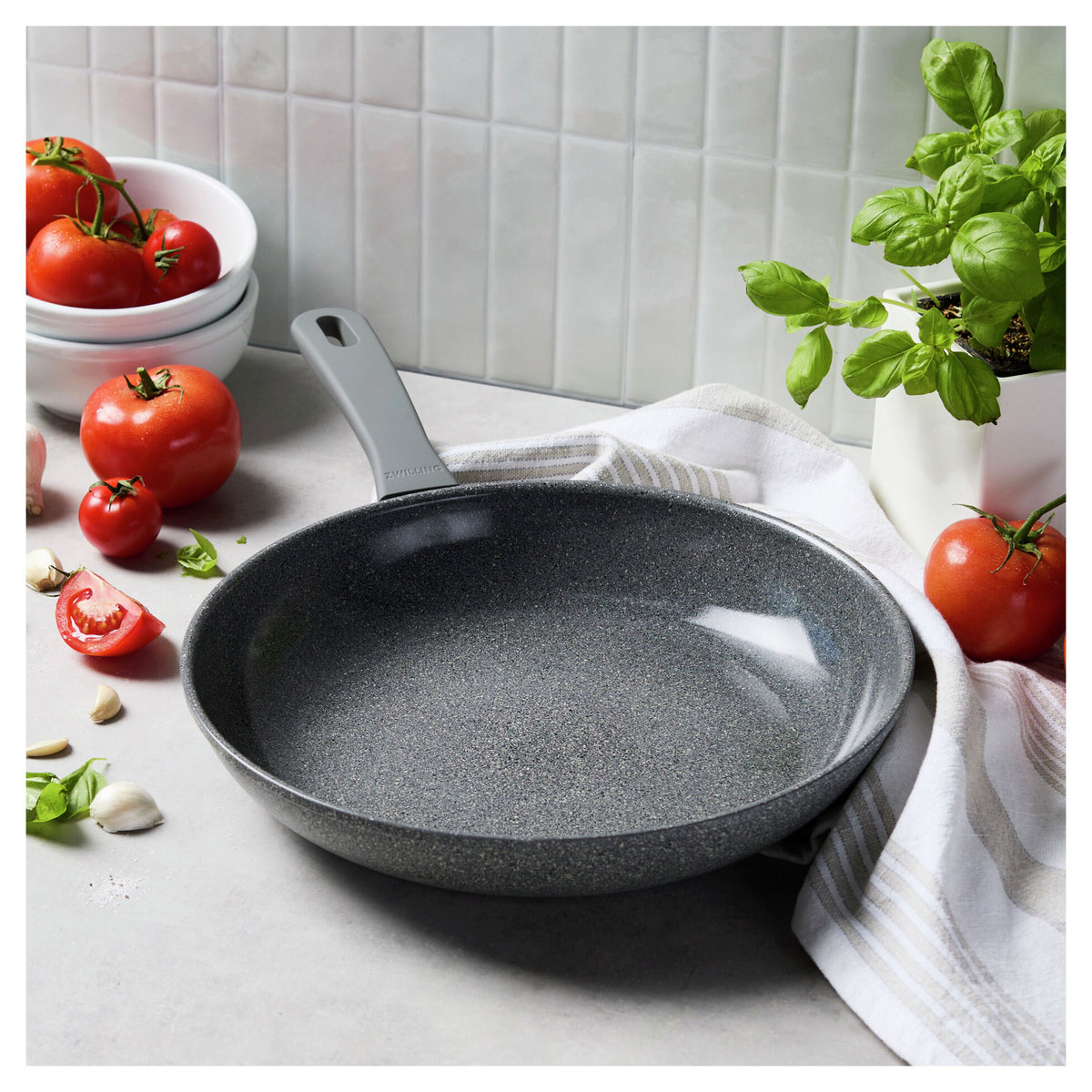 12" Parma Plus, Nonstick Ceramic Fry Pan in a kitchen next to a towel and produce