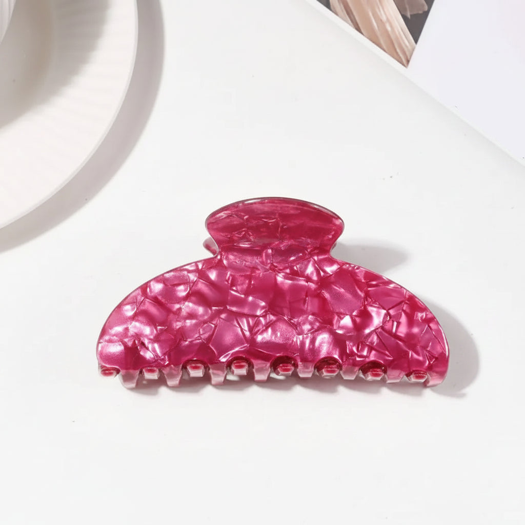 A glossy pink claw hair clip shown on a white background
