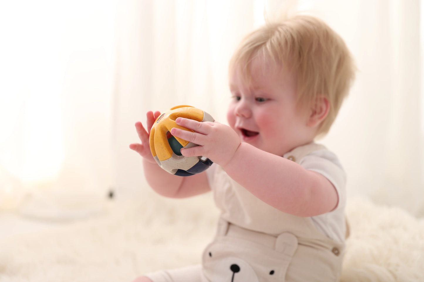 baby playing with tolo rolling ball.