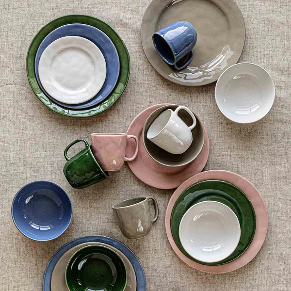 Puro dishes in taupe, blush, chambray, white and basil on a linen background
