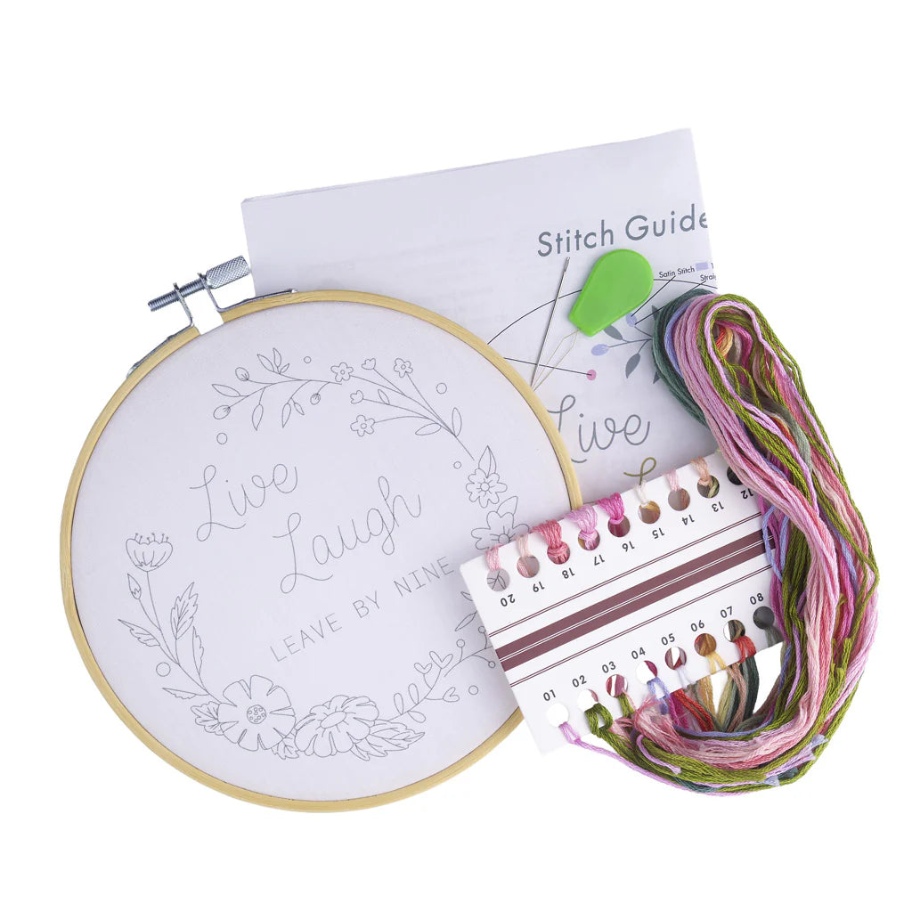 Embroidery kit with hoop, thread, and stitch guide on a white background