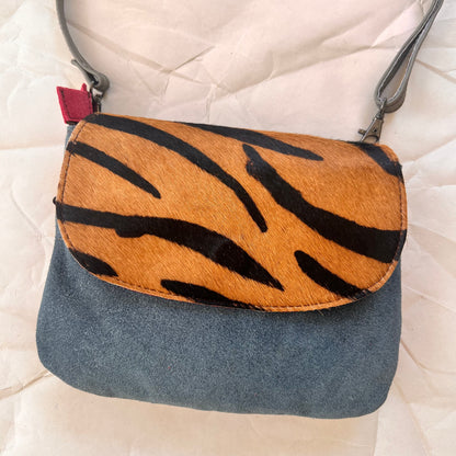 leo purse with blue body and animal print flap.